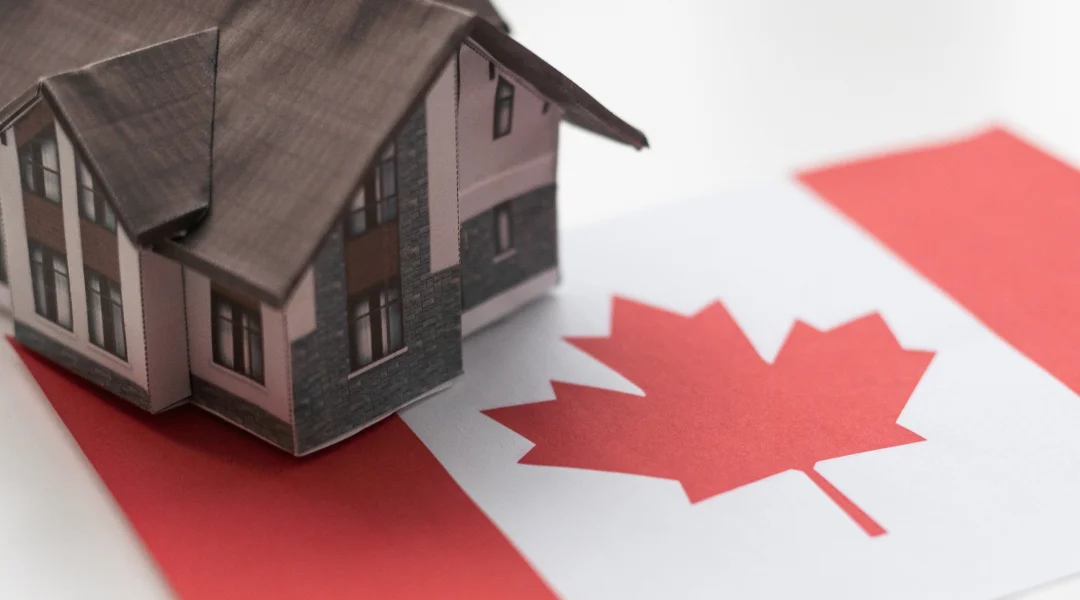 Maison canadienne sur un drapeau canadien, symbolisant l'excellence en courtage immobilier.